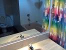 Modern bathroom with colorful shower curtain and clean facilities