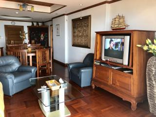 Spacious living room with wooden furnishings and hardwood floors