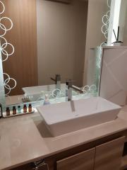 Modern bathroom sink with vanity mirror and toiletries