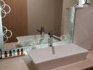 Modern bathroom sink with vanity mirror and toiletries