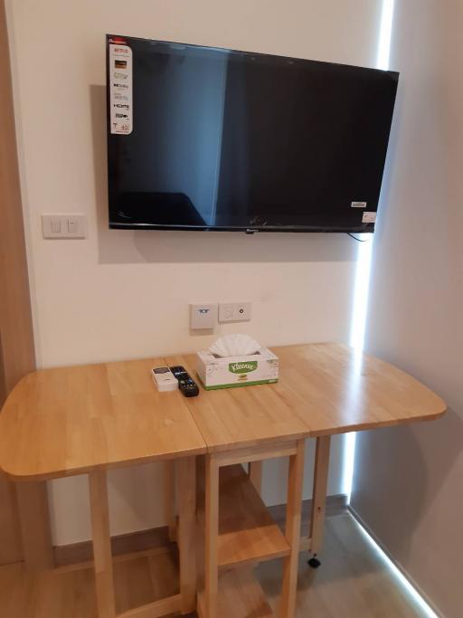 Modern living room with wall-mounted television and wooden dining table