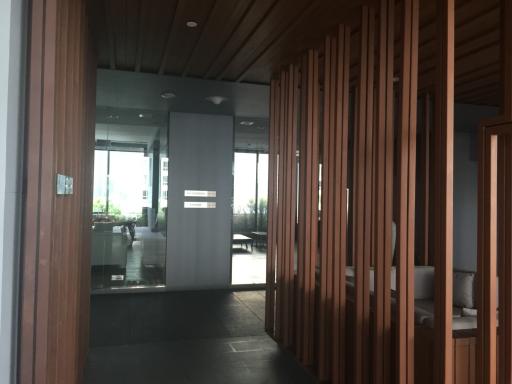 Modern interior view of a building with wooden slats and a glimpse into the living space