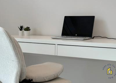 Modern home office with a laptop on the desk and a comfortable chair