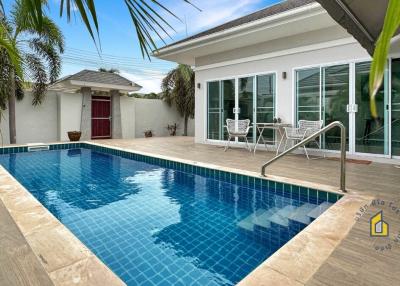 Private swimming pool with surrounding patio and tropical landscaping at residential property