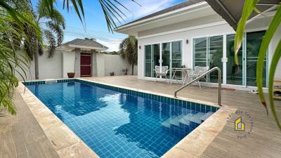 Private swimming pool with surrounding patio and tropical landscaping at residential property