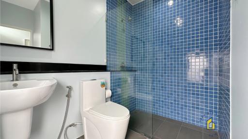 Modern bathroom with blue mosaic tiles and white fixtures