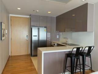 Modern kitchen with stainless steel appliances, wooden flooring, and breakfast bar