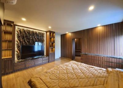 Modern bedroom with large bed and wooden wall paneling