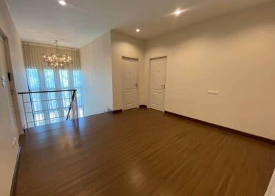 Spacious well-lit living room with hardwood floors and modern lighting