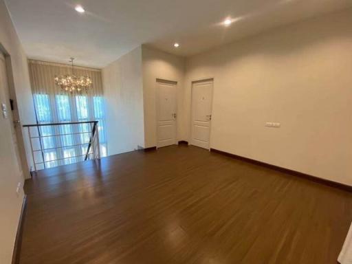 Spacious well-lit living room with hardwood floors and modern lighting