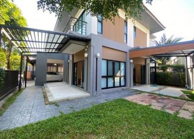 Modern two-story house with attached carport and landscaped front yard