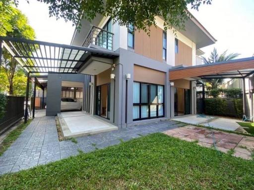 Modern two-story house with attached carport and landscaped front yard