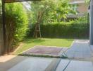 Spacious backyard with lush greenery and a paved path