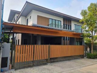 Modern two-story house with a wooden fence