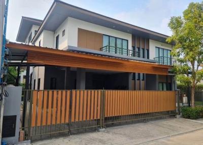 Modern two-story house with a wooden fence