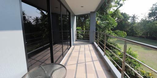 Spacious balcony with a view of greenery and seating area