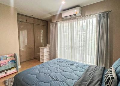 Cozy bedroom with a large bed, ample wardrobe, and air conditioning