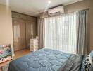 Cozy bedroom with a large bed, ample wardrobe, and air conditioning