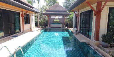 Private swimming pool with gazebo and tropical plants in a luxurious home