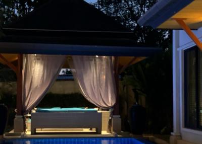 Elegant backyard with a gazebo and pool illuminated at twilight