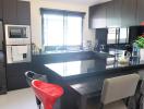 Modern kitchen with black appliances and dining area