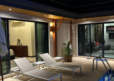 Modern outdoor patio with pool, lounging chairs, and access to indoor spaces