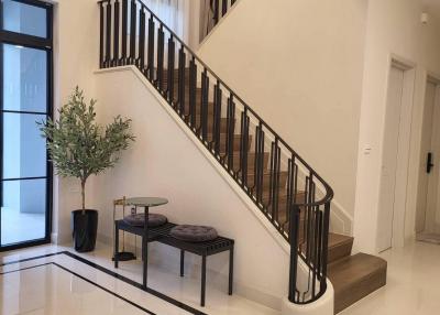 Elegant entryway with staircase, modern decor and natural lighting