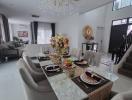 Elegant dining area with large chandelier over table set for a meal