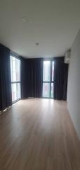 Spacious unfurnished living room with large windows and hardwood flooring