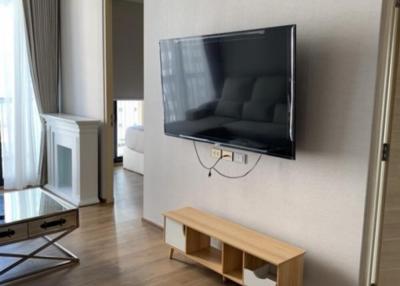 Modern living room with mounted television and wooden flooring