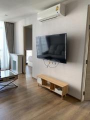 Modern living room with mounted television and wooden flooring