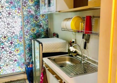 Compact and colorful kitchen with modern appliances and floral wallpaper