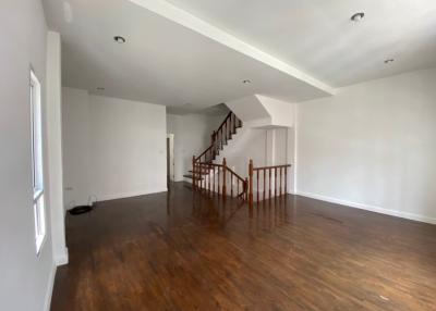 Spacious living room with hardwood floors and staircase