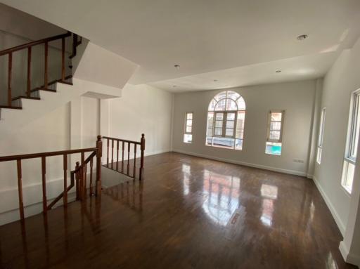 Spacious living room with natural light and elegant staircase