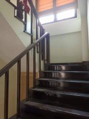 Wooden staircase with handrails inside a home, leading to an upper floor
