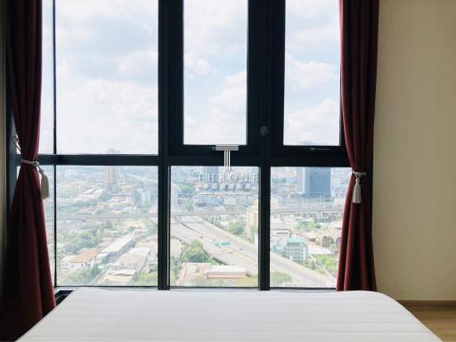 Bright bedroom with large windows and city view