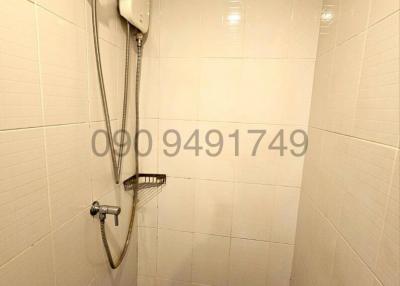 Compact bathroom shower with wall-mounted heater and handheld shower head