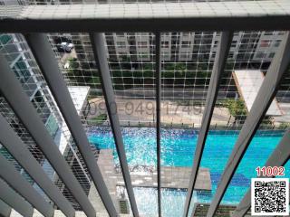 View from a balcony with swimming pool and buildings in the background