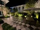 Elegant garden area with checkered pathway and outdoor seating at night