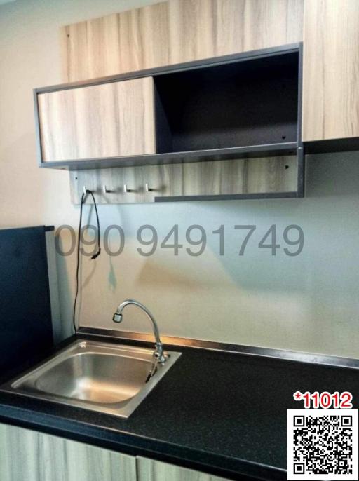 Compact kitchen area with stainless steel sink and modern cabinetry