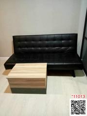 Compact living room with black sofa and wooden table