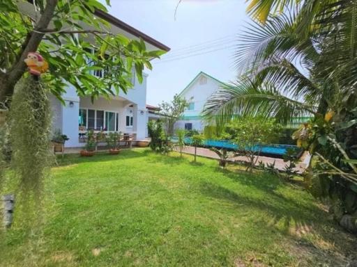 Cozy backyard with lawn, pool, and partial view of the house