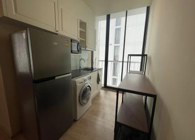 Compact modern kitchen with stainless steel appliances and balcony access