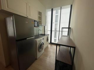 Compact modern kitchen with stainless steel appliances and balcony access