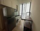 Compact modern kitchen with stainless steel appliances and balcony access