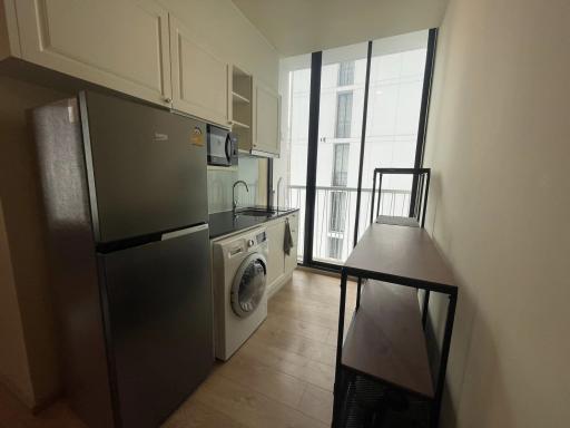 Compact modern kitchen with stainless steel appliances and balcony access