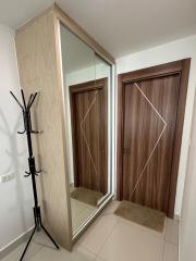 Modern entryway with mirrored closet and wooden doors