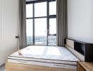 Modern bedroom with a large window and city view