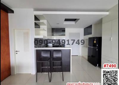 Modern kitchen with bar seating and tiled flooring in apartment