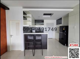 Modern kitchen with bar seating and tiled flooring in apartment